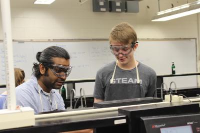 Bharath Kumar (left), a doctoral student in STEM education at UK, helps a STEAM Academy student with a chemistry project.