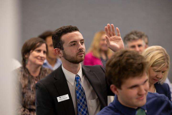 A student raises their hand with a question